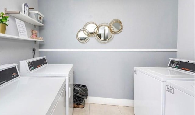 laundry room featuring washing machine and clothes dryer and light tile patterned flooring