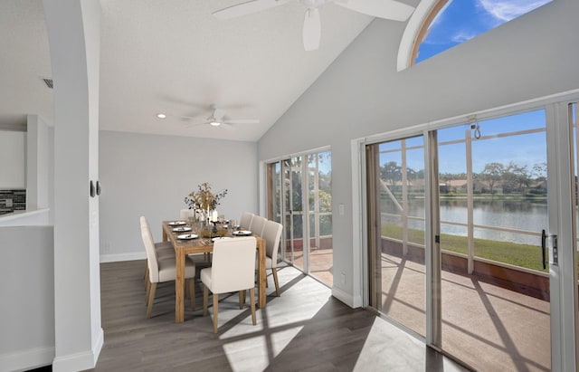 sunroom featuring lofted ceiling, ceiling fan, and a water view