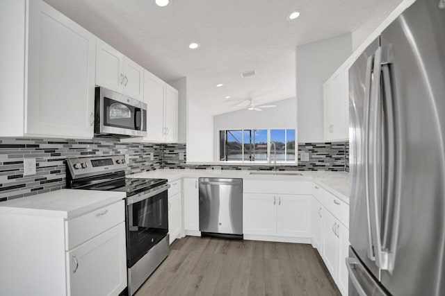 kitchen with stainless steel appliances, sink, and white cabinets