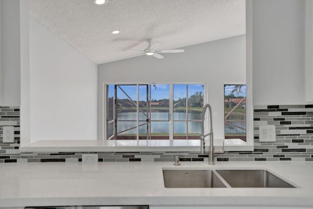 kitchen featuring plenty of natural light, a ceiling fan, lofted ceiling, and a sink