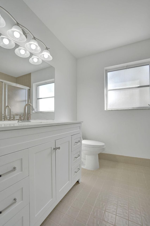 bathroom featuring vanity, toilet, and a shower stall