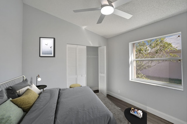 bedroom with hardwood / wood-style flooring, ceiling fan, a textured ceiling, vaulted ceiling, and a closet