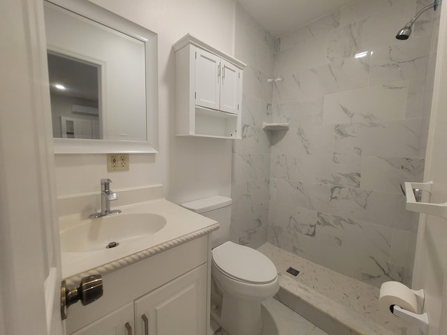 bathroom featuring vanity, toilet, and tiled shower