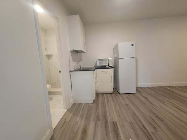 laundry room featuring sink and light hardwood / wood-style flooring