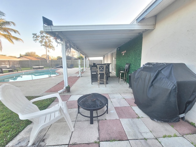 view of patio featuring a grill, a fire pit, and a fenced in pool