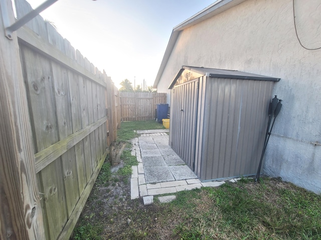 view of side of home featuring a storage shed