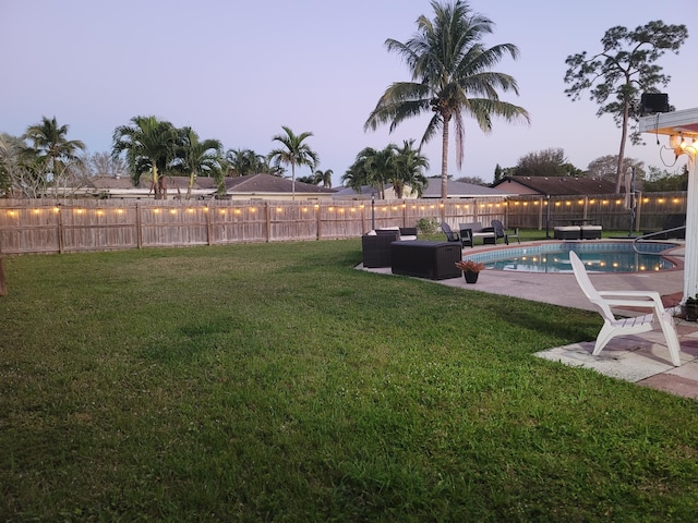 yard at dusk featuring a fenced in pool, a patio area, and outdoor lounge area