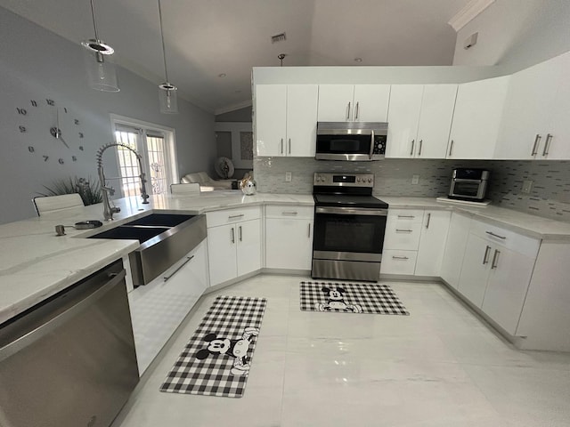 kitchen featuring stainless steel appliances, lofted ceiling, a sink, tasteful backsplash, and crown molding
