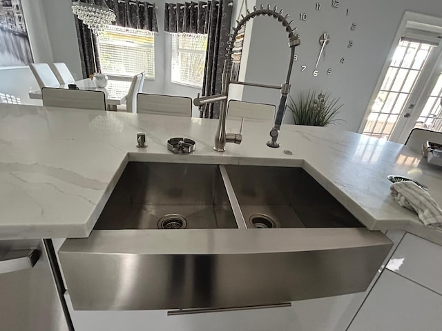 kitchen view of a sink and light stone counters