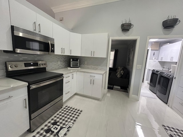 kitchen featuring appliances with stainless steel finishes, washer and dryer, crown molding, tasteful backsplash, and light countertops
