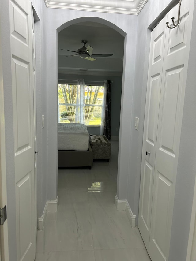 hallway with baseboards and ornamental molding