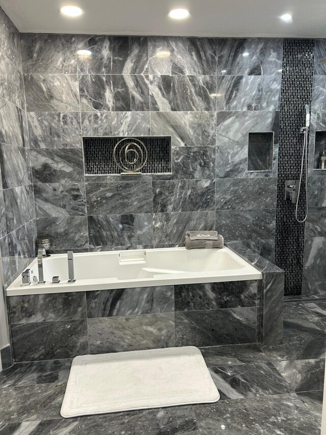 bathroom with tiled bath, a shower, tile walls, marble tiled flooring, and recessed lighting