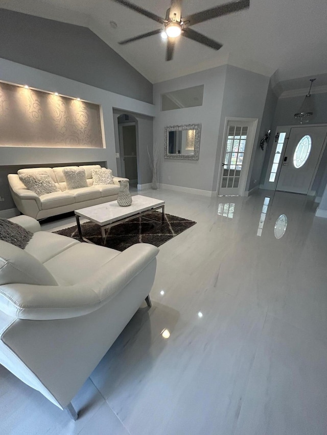 living area featuring a ceiling fan, lofted ceiling, light marble finish floors, and baseboards