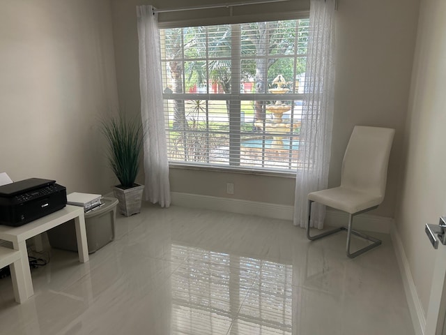 sitting room with healthy amount of natural light, tile patterned floors, and baseboards