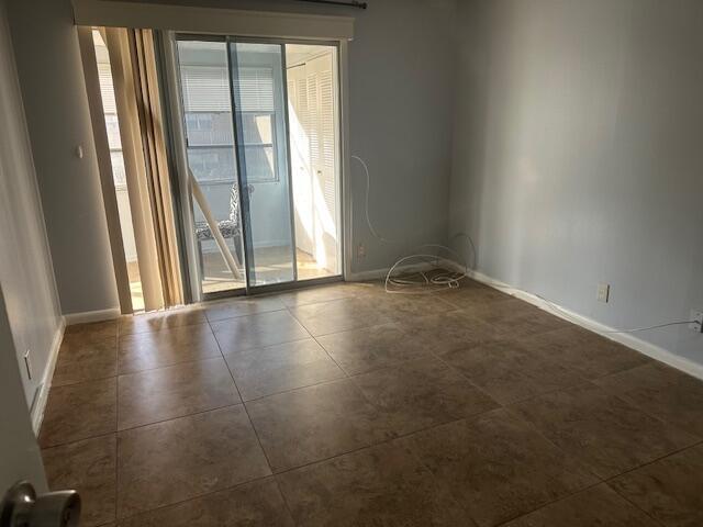 spare room featuring dark tile patterned floors