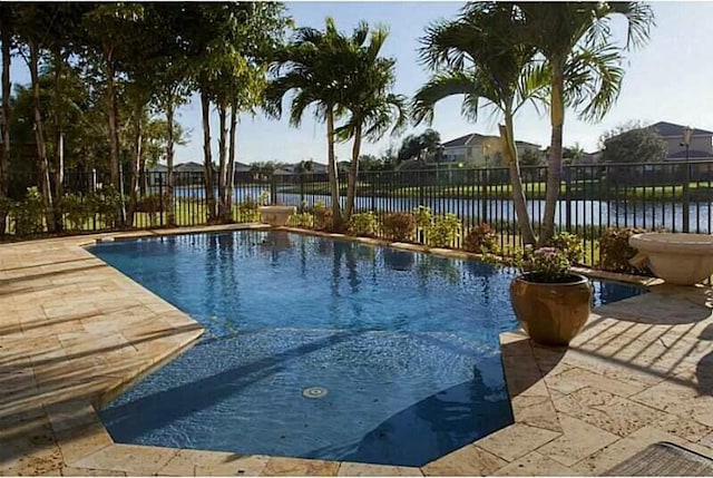 view of swimming pool featuring a water view and a patio area