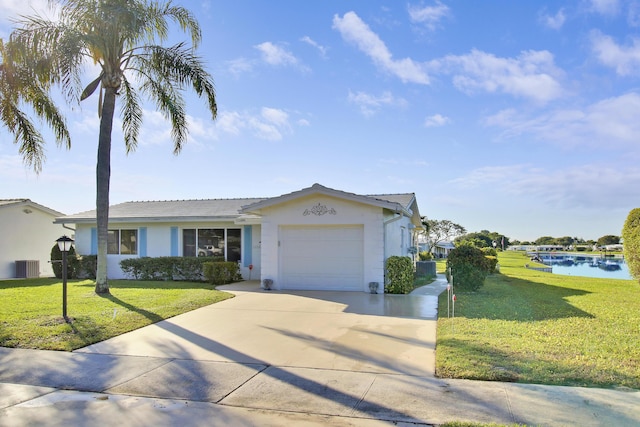 view of front of home with a garage, a water view, a front yard, and central AC unit