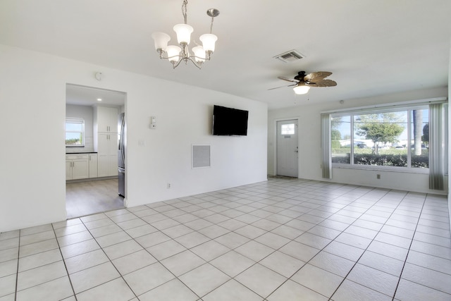 unfurnished living room featuring light tile patterned floors and ceiling fan with notable chandelier