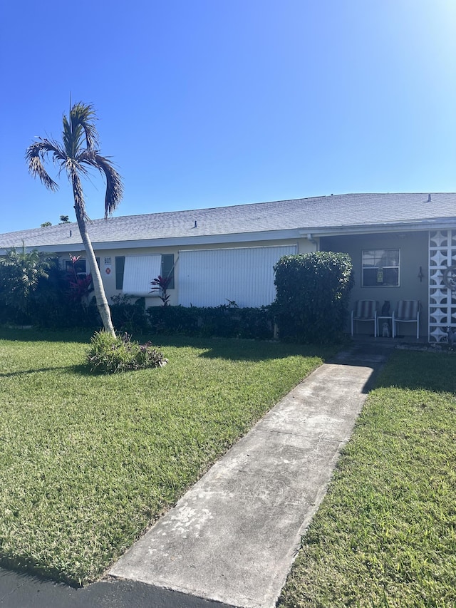 single story home featuring a front lawn