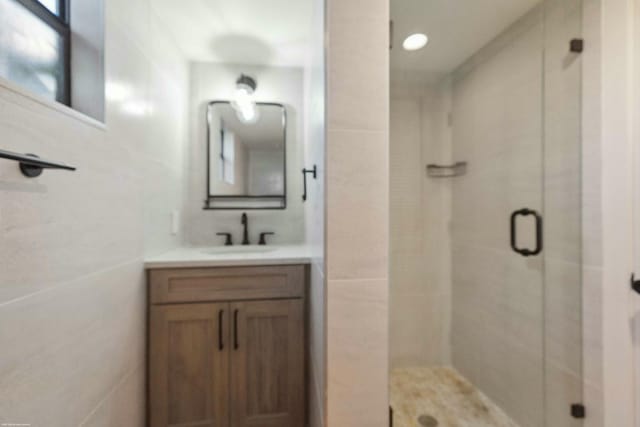 bathroom with a shower with door and vanity