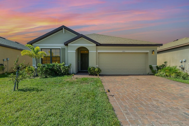 single story home with a garage and a yard