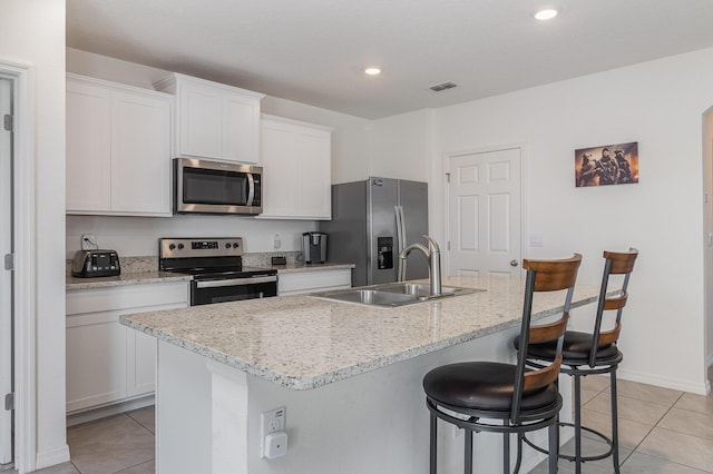 3580 Foggy Mist Rd SE, Palm Bay, FL 32909 - kitchen featuring stainless steel appliances, light tile patterned floors, an island with sink, a breakfast bar, and recessed lighting