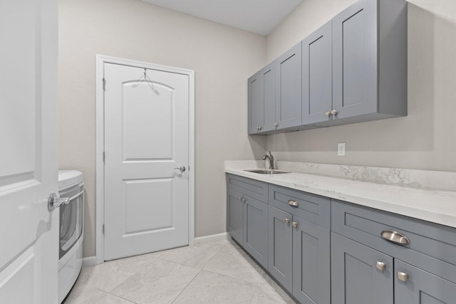 laundry room featuring cabinets, sink, and washing machine and clothes dryer