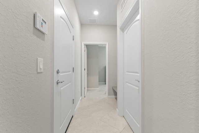 hall with light tile patterned floors