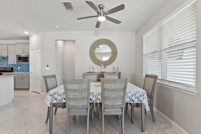 tiled dining area featuring ceiling fan