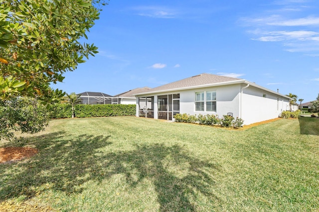 back of property with a sunroom and a yard