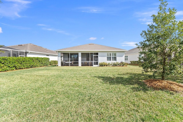 rear view of property with a sunroom and a lawn