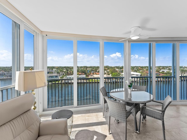 sunroom / solarium with a water view and ceiling fan