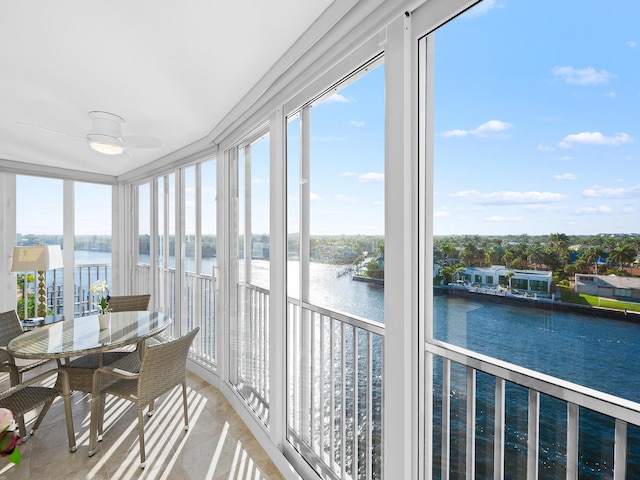 sunroom / solarium featuring ceiling fan, a water view, and plenty of natural light