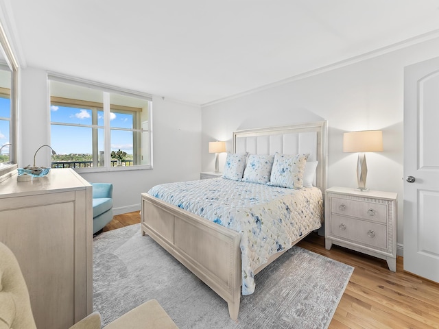 bedroom featuring light hardwood / wood-style floors and crown molding