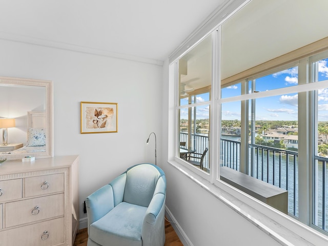 living area with a water view and ornamental molding