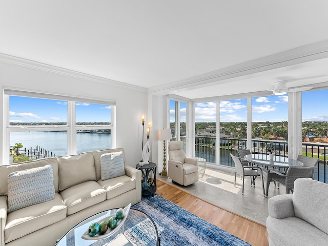 living room with ornamental molding, hardwood / wood-style flooring, floor to ceiling windows, and a water view