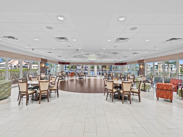 dining space featuring a drop ceiling and a wealth of natural light