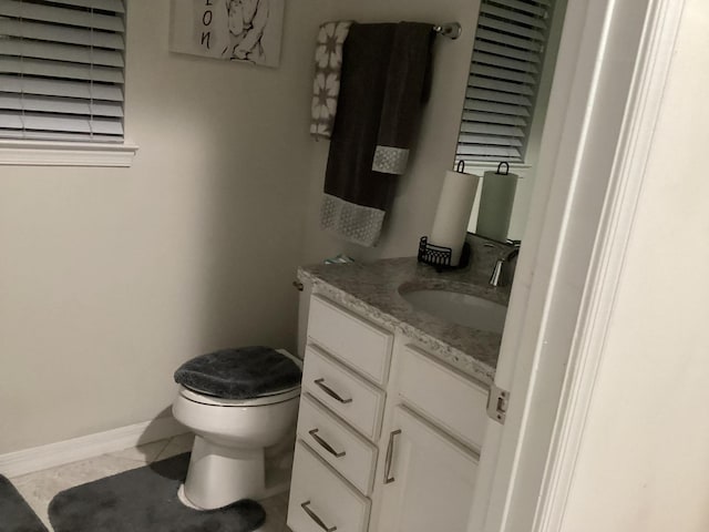 bathroom with tile patterned flooring, vanity, and toilet