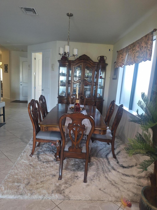 tiled dining room with a chandelier