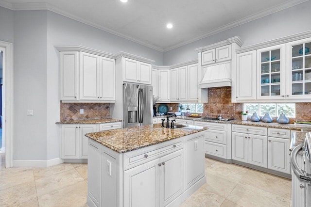 kitchen with white cabinetry, stainless steel fridge with ice dispenser, sink, and a center island