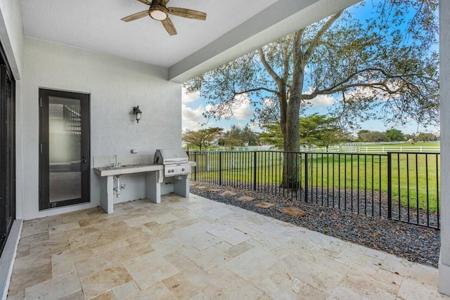 view of patio featuring area for grilling, sink, and ceiling fan