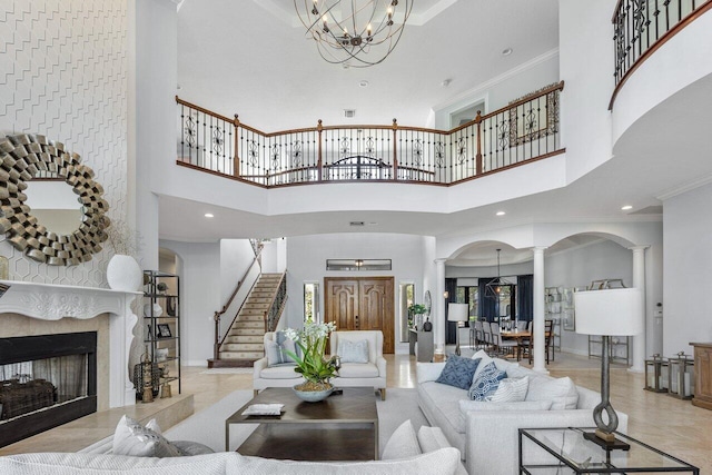 living room with decorative columns, crown molding, and an inviting chandelier