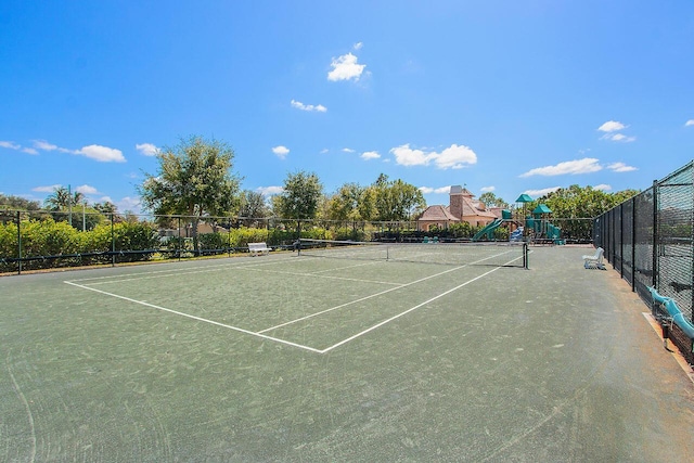 view of tennis court featuring a playground