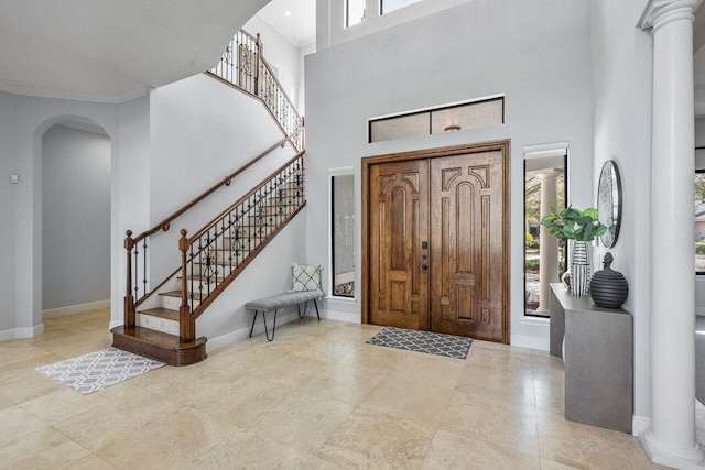 entrance foyer featuring a towering ceiling and ornamental molding