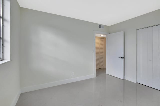 unfurnished bedroom with light tile patterned floors and a closet