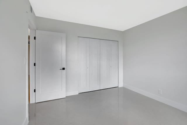 unfurnished bedroom with tile patterned flooring and a closet