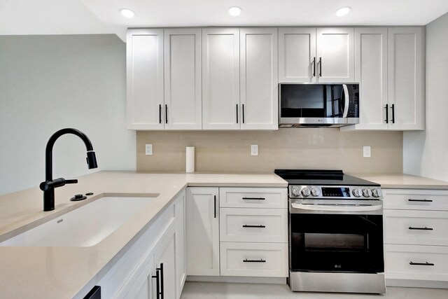 kitchen with light countertops, a sink, recessed lighting, and stainless steel appliances