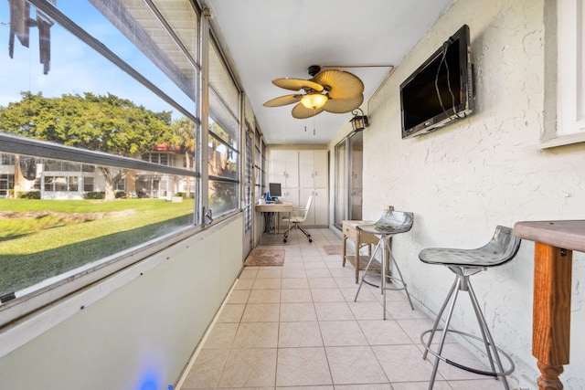 sunroom / solarium featuring ceiling fan