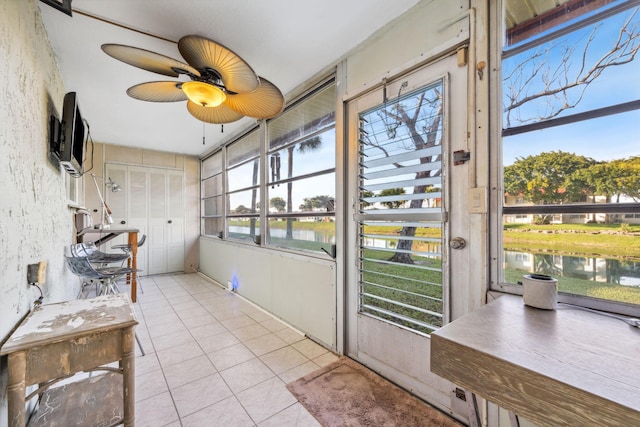 sunroom / solarium with a water view and ceiling fan