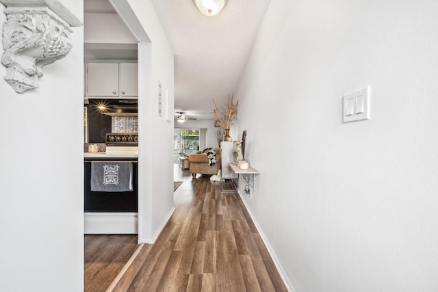 hall featuring dark wood-type flooring and a textured ceiling